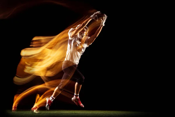 Портрет молодого человека, американского футболиста тренировки изолированы на темном фоне студии со смешанным неоновым светом. Концепция спорта, соревнования и красоты — стоковое фото