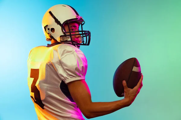 Yakın plan erkek Amerikan futbolcu eğitimi mavi arka planda neon ışıkta izole edildi. Spor anlayışı, rekabet — Stok fotoğraf