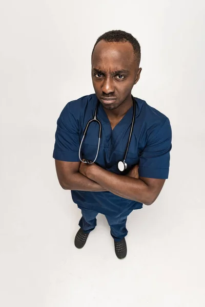 Vista de ángulo alto del joven médico africano, consejero terapéutico o médico en el trabajo. Emociones de memes graciosas. Concepto de salud, medicina del cuidado y humor. Primer plano — Foto de Stock