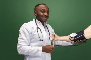 Yeşil arka planda Afrikalı genç doktor, terapötik ya da tıbbi danışman görüntüsü. Sağlık, bakım ve ilaç kavramı. Yakın plan.