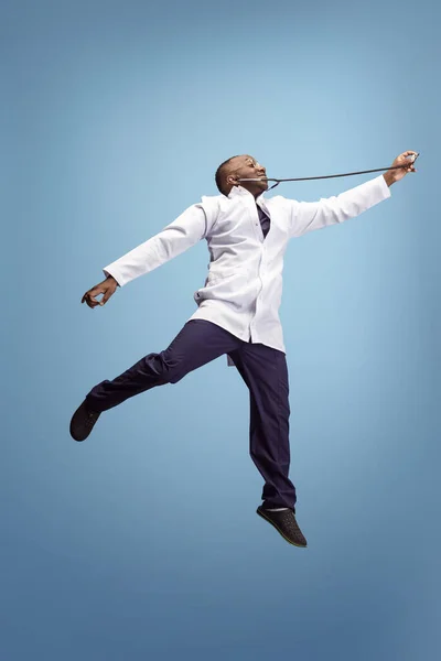 One funny doctor, therapeutic or medical advisor posing isolated on blue studio back ground. Funny meme emotions. Concept of healthcare, care, medicine and humor. — Stock Photo, Image