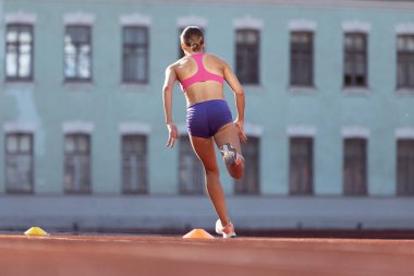 Yakın mesafeden profesyonel bayan atlet, halk stadyumunda koşucu eğitimi, spor sahası ya da açık hava sahası. Sağlıklı yaşam tarzı, profesyonel spor, sağlık kavramı
