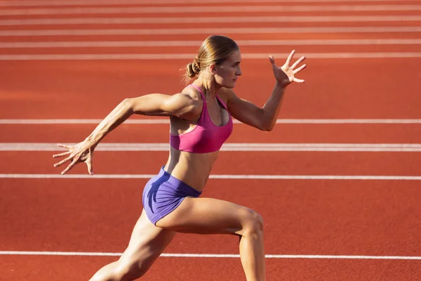 Une femme caucasienne, athlète féminine, coureuse s'entraînant au stade public, au terrain de sport ou au terrain de jeu en plein air. Jeux de sport d'été. — Photo