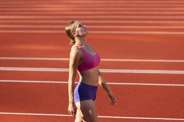 Une femme caucasienne, athlète féminine, coureuse s'entraînant au stade public, au terrain de sport ou au terrain de jeu en plein air. Jeux de sport d'été. — Photo
