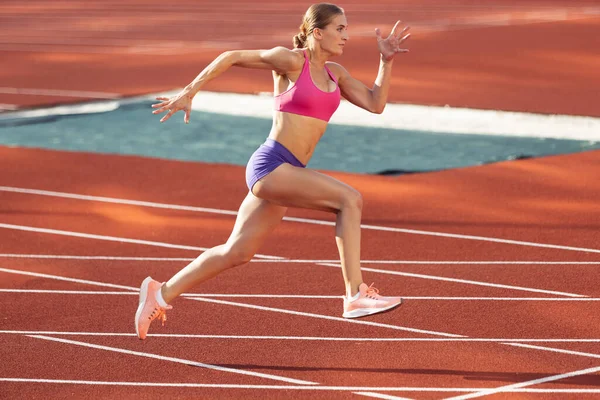 Track-and-field athletics. Young Caucasian woman, professional athlete, runner training at public stadium, sport court, outdoors. Concept of sport, achievment, motion. — Stock Photo, Image