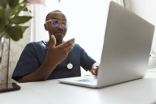 Un joven médico africano, consejero terapéutico o médico utilizando portátil, consultoría en línea. Concepto de salud, cuidado, medicina y ocupación profesional — Foto de Stock