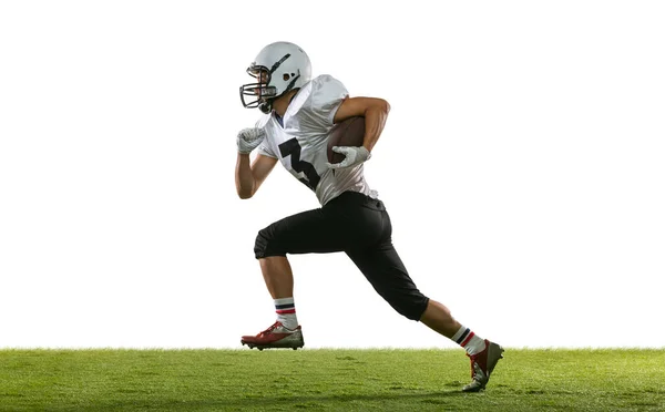 Portrait of American football player training isolated on white studio background with green grass. Concept of sport, competition — Stock Photo, Image