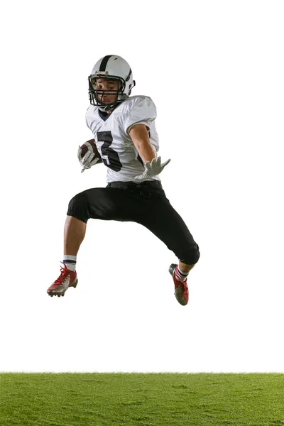 Portret van Amerikaanse football speler training geïsoleerd op witte studio achtergrond met groen gras. Begrip sport, concurrentie — Stockfoto