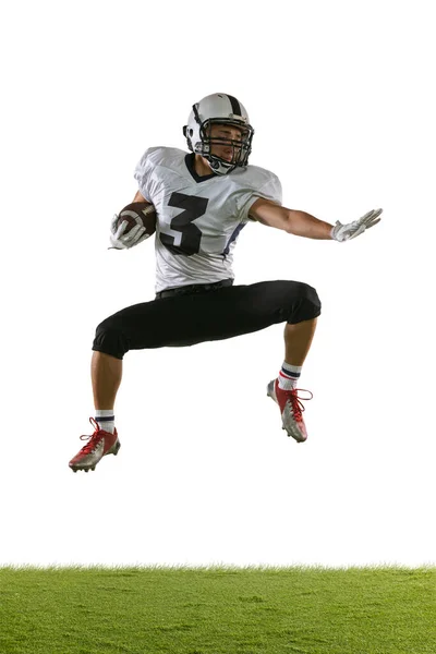 Retrato de entrenamiento de jugador de fútbol americano aislado en el fondo del estudio blanco con hierba verde. Concepto de deporte, competición — Foto de Stock