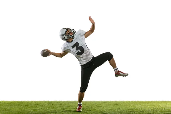 Ritratto di giocatore di football americano che si allena isolato su sfondo bianco da studio con erba verde. Concetto di sport, competizione — Foto Stock