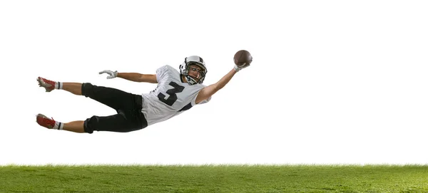 Portrait of American football player training isolated on white studio background with green grass. Concept of sport, competition — Stock Photo, Image