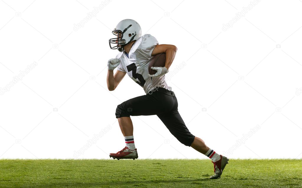 Portrait of American football player training isolated on white studio background with green grass. Concept of sport, competition