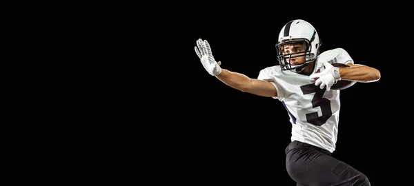 Close-up portrait of American football player playing in sports equipment, helmet and gloves isolated on dark studio background. Concept of sport, competition — Stock Photo, Image