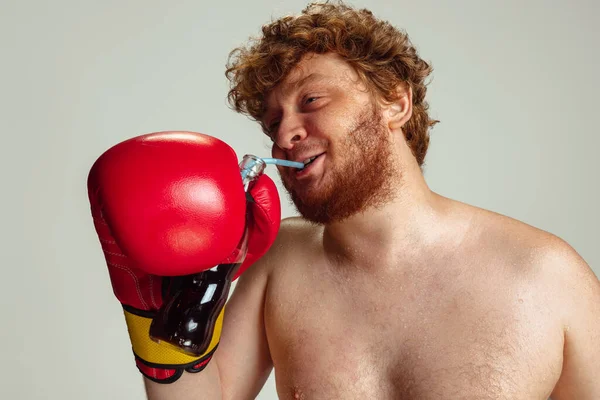 Close-up grappige roodharige man in blauwe boksbroek en handschoenen geïsoleerd op grijze studio achtergrond. Concept van sport, humor en lichaam positief. — Stockfoto