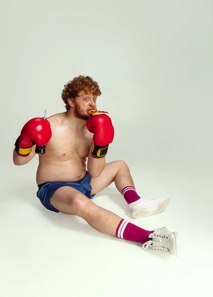 Homem ruivo engraçado em calções de boxe azuis e luvas isoladas em fundo de estúdio cinza. Conceito de esporte, humor e corpo positivo. — Fotografia de Stock