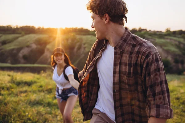 Primer plano joven hombre y mujer, pareja de amantes caminando, paseando juntos a las afueras de la ciudad, en el bosque de verano. Estilo de vida activo, viajes, concepto de reunión —  Fotos de Stock