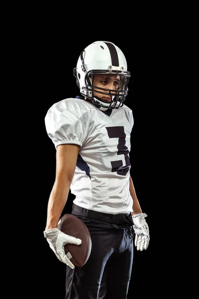 Retrato de um jogador de futebol americano em equipamento desportivo capacete e luvas isoladas sobre fundo estúdio escuro. Conceito de desporto, competição — Fotografia de Stock