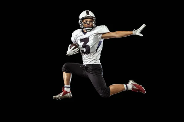 Un volo fantastico. Un atleta professionista che gioca a football americano isolato su uno sfondo scuro. Concetto di sport, competizione — Foto Stock