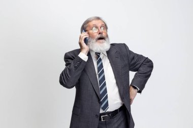 Gri saçlı yaşlı adam, profesör, öğretmen gri stüdyo arka planında izole edilmiş poz veriyor. Meslek mesleği, iş, eğitim ve motivasyon kavramı.