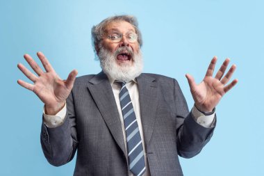 Çılgın profesör, öğretmen, gri sakallı adam gri stüdyo arka planında yalnız poz veriyor. Meslek mesleği kavramı, iş, eğitim, komik mim duyguları