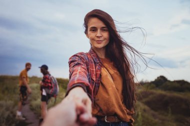 - Benimle gel. Güzel bir kız adamı elleriyle tutuyor ve dağ vadisinde yürüyor kameraya bakıyor ve gülümsüyor. Aktif yaşam tarzı, arkadaşlık, bakım, ekoloji kavramı