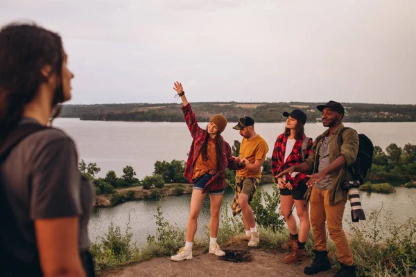 Groupe d'amis, jeunes hommes et femmes marchant, se promenant ensemble en périphérie de la ville, dans la forêt d'été, prairie. Style de vie actif, amitié, soins, concept écologique — Photo