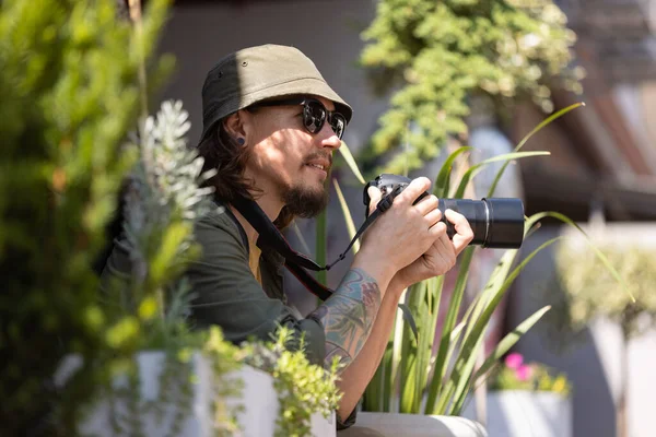 Portrait de jeune homme, photographe, caméraman avec appareil photo professionnel, équipement pendant la journée de travail d'été à l'extérieur. Notion de profession, d'emploi, d'éducation — Photo