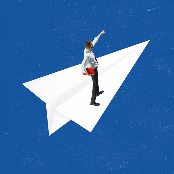 Başarılı bir iş adamı, başarı ve hedefe giden yolda beyaz kağıt uçağın üzerinde duruyor. Doğru yön. — Stok fotoğraf