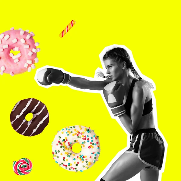 Ajuste mujer joven luchando contra la mala comida, esmalte pasteles en el fondo de color. Boxeo femenino con rosquillas dulces. Concepto de alimentación saludable. — Foto de Stock