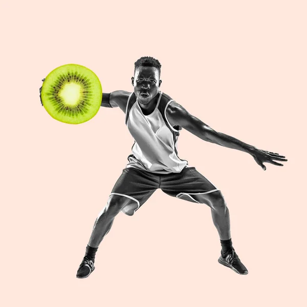 Renkli arka planda güzel yemekleri olan zinde bir genç. Top olarak kivi meyvesi olan erkek basketbolcu. Sağlıklı yeme kavramı. — Stok fotoğraf