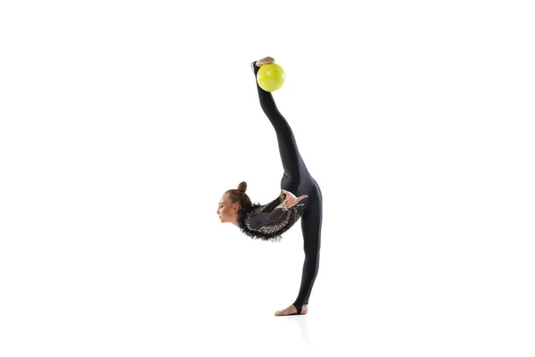 Jovem atleta feminina, artista de ginástica rítmica isolada em fundo de estúdio branco. Menina bonita praticando com bola. Conceito de esporte, ação, aspiração — Fotografia de Stock