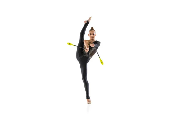 Una chica caucásica, artista de gimnasia rítmica practicando con bastón aislado sobre fondo blanco del estudio. Concepto de deporte, acción, aspiración, educación, estilo de vida activo — Foto de Stock