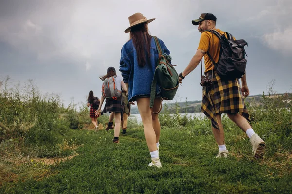 Joven hombre y mujer, pareja familiar caminando, paseando juntos a las afueras de la ciudad, en el bosque de verano. Estilo de vida activo, viajes, eco, concepto de relación — Foto de Stock