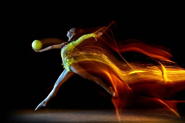 Портрет молодой девушки, художника художественной гимнастики в действии изолирован на темном студийном фоне со смешанным светом. Мбаппе о спорте, экшне, красоте — стоковое фото