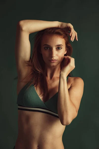 Retrato de close-up de jovem bela mulher ruiva sem maquiagem isolada sobre fundo de estúdio verde escuro. Conceito de beleza natural. — Fotografia de Stock