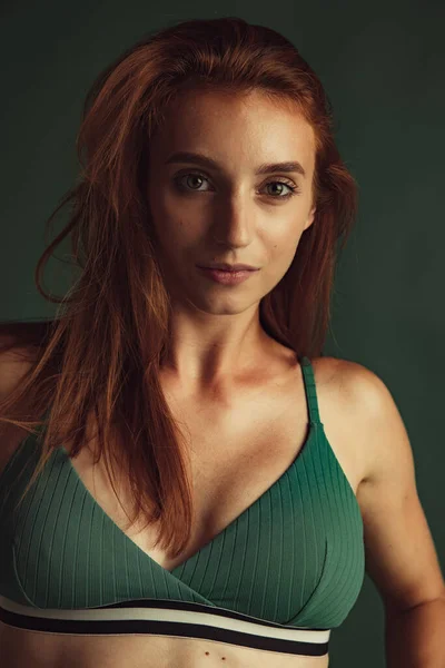 Close-up portrait of young beautiful red-headed woman without makeup isolated over dark green studio background. Natural beauty concept. — Stock Photo, Image