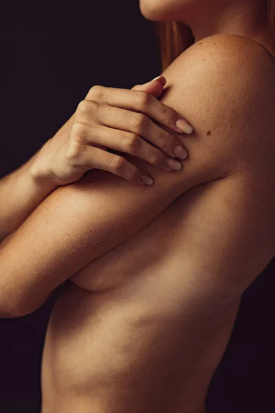 Imagen recortada de una joven hermosa mujer desnuda posando aislada sobre un fondo de estudio oscuro. Concepto de belleza natural. — Foto de Stock