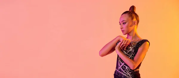 Volante con chica joven, artista de gimnasia rítmica en traje de escenario, traje deportivo aislado en fondo de estudio amarillo rosa en neón. Concepto de deporte — Foto de Stock