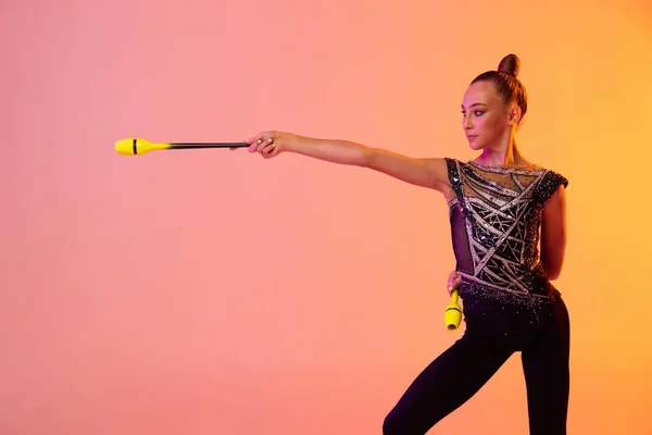 白种人少女,专业的艺术体操训练,背景为粉红黄色,背景为霓虹灯.体育的概念，美 — 图库照片