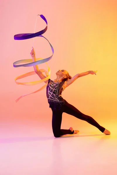 네온의 핑크 색 노란색 스튜디오 배경에서 고립된 리듬 체조 아티스트, 어린 소녀의 초상화. 스포츠, 행동, 열망, 교육, 활동적 인 생활 양식의 개념 — 스톡 사진
