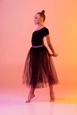 Bir genç kız, sahne kıyafetli ritmik jimnastik sanatçısı, neon rengi pembe sarı stüdyo arka planında izole edilmiş spor kostümü. Spor anlayışı