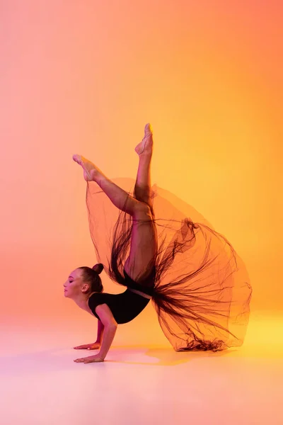 小女孩的肖像，节奏体操艺术家孤立在粉红黄色工作室背景的霓虹灯。体育、行动、愿望、教育、积极生活方式的概念 — 图库照片