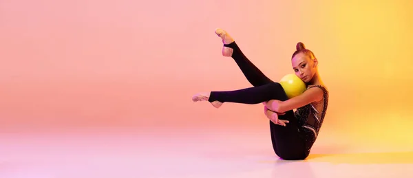 Flyer avec jeune fille, artiste de gymnastique rythmique en tenue de scène, costume de sport isolé sur fond studio jaune rose en néon. Concept de sport — Photo