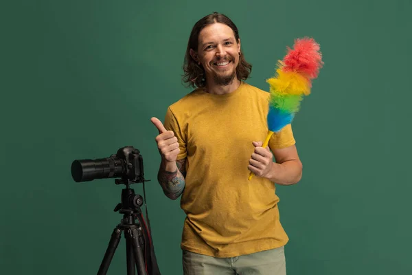 Comic πορτρέτο του νέου άνδρα, φωτογράφος, κάμεραμαν με ρετρό κάμερα διασκεδάζοντας απομονωμένο σε πράσινο φόντο στούντιο. Έννοια του επαγγέλματος, δουλειά, αστεία συναισθήματα meme — Φωτογραφία Αρχείου