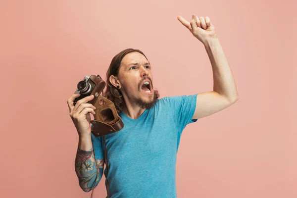 Porträt eines jungen Mannes, Fotograf, Kameramann mit Retro-Kamera isoliert auf rosa Studiohintergrund. Begriffe wie Beruf, Job, lustige Meme — Stockfoto