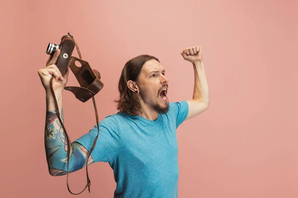 Portré fiatal férfi, fotós, operatőr retro kamera elszigetelt rózsaszín stúdió háttér. Fogalom foglalkozás, munka, vicces mém érzelmek — Stock Fotó
