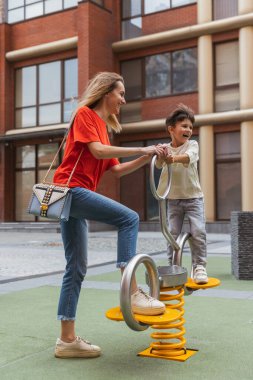 İki kişi, anne ve küçük tatlı oğlu sokakta dolaşıyorlar, yazın ticaret meydanında, açık havada. Aile zamanı, birliktelik, ebeveynlik ve mutlu çocukluk kavramı..