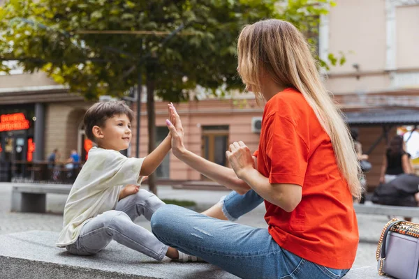 Two people, mother and little cute son strolling at street, trade square in summer time, outdoors. Family time, togehterness, parenting and happy childhood concept. — Stock Photo, Image