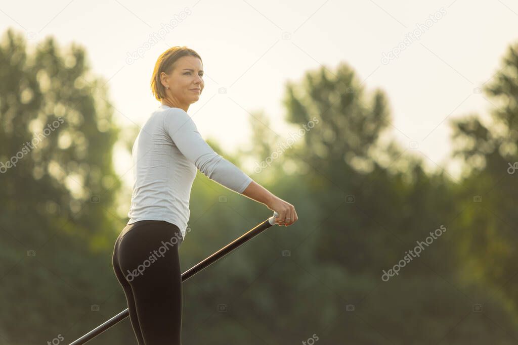 Close-up portrait of young Caucasian woman, sportsman practicing, training alone at summer evening, outdoors. Active life, sport, leisure activity concept