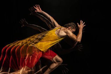 Genç bir adamın portresi, profesyonel erkek atlet, hareketli koşucu ve karanlık arka planda izole edilmiş hareket. Stroboskop etkisi.